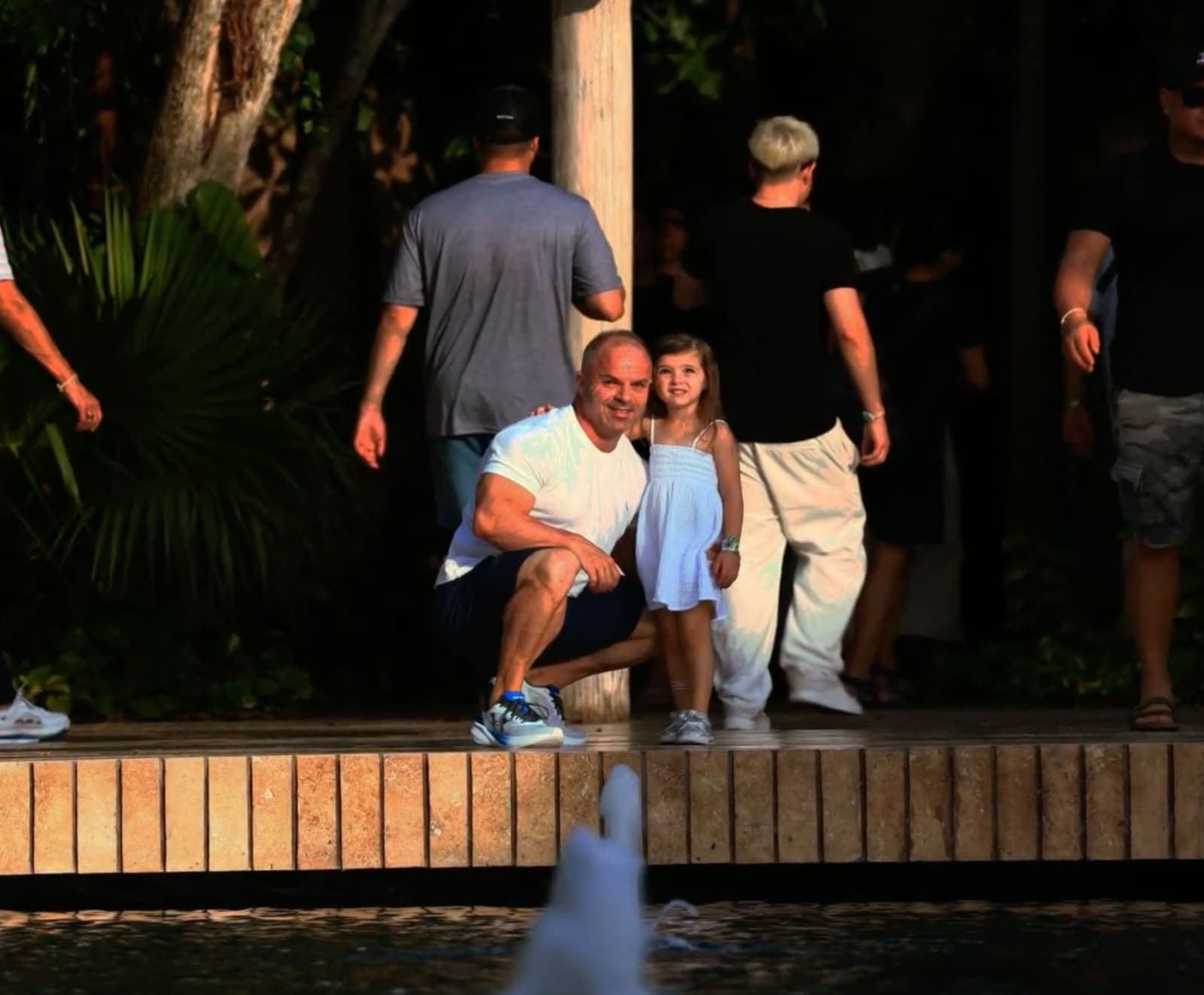 A parent and small child beside the water at Hotel Xcaret Mexico in the early evening