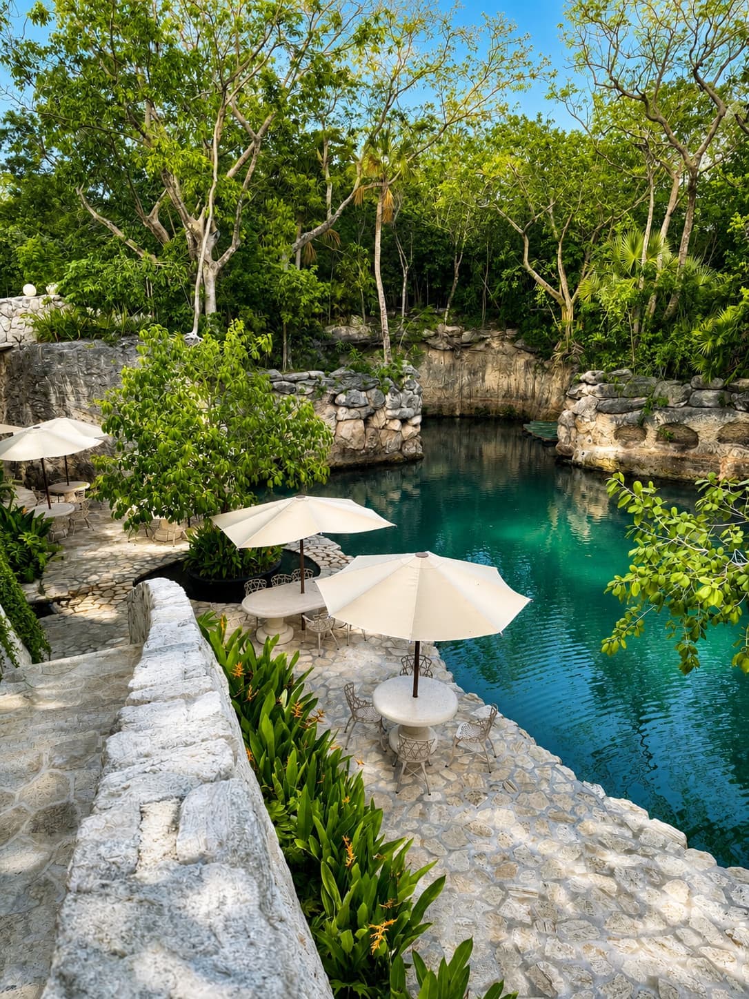La Silla's stone terrace and umbrella tables above the emerald lagoon at Hotel Xcaret México