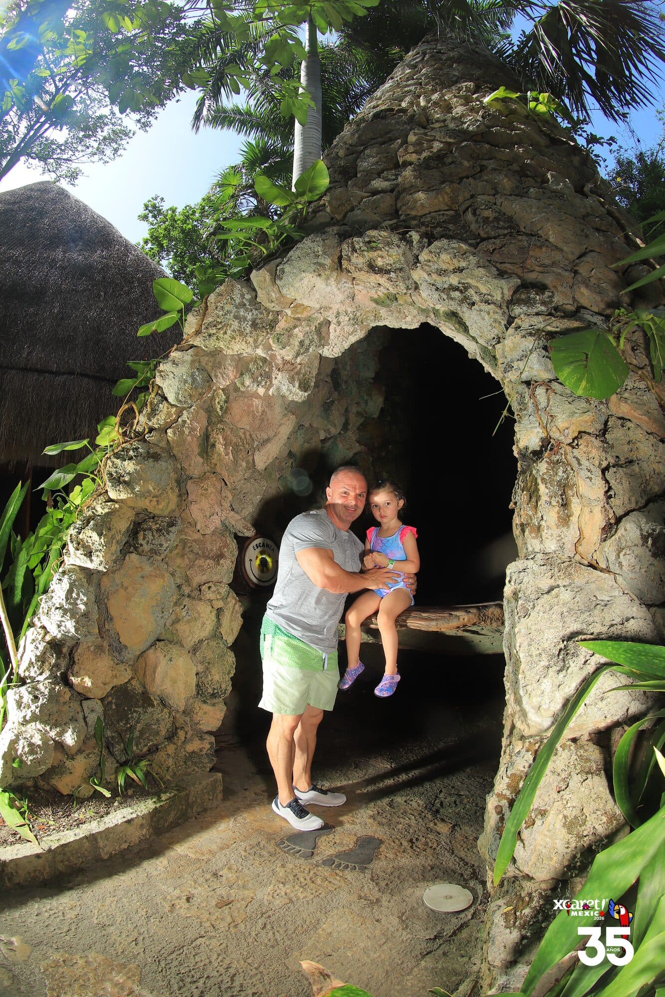 Walking a small child through one of the stone cave tunnels at Xcaret park