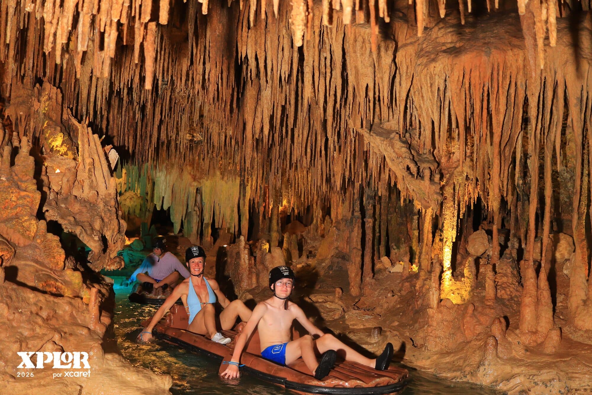 Paddling a raft by hand along the underground river inside an Xplor cave