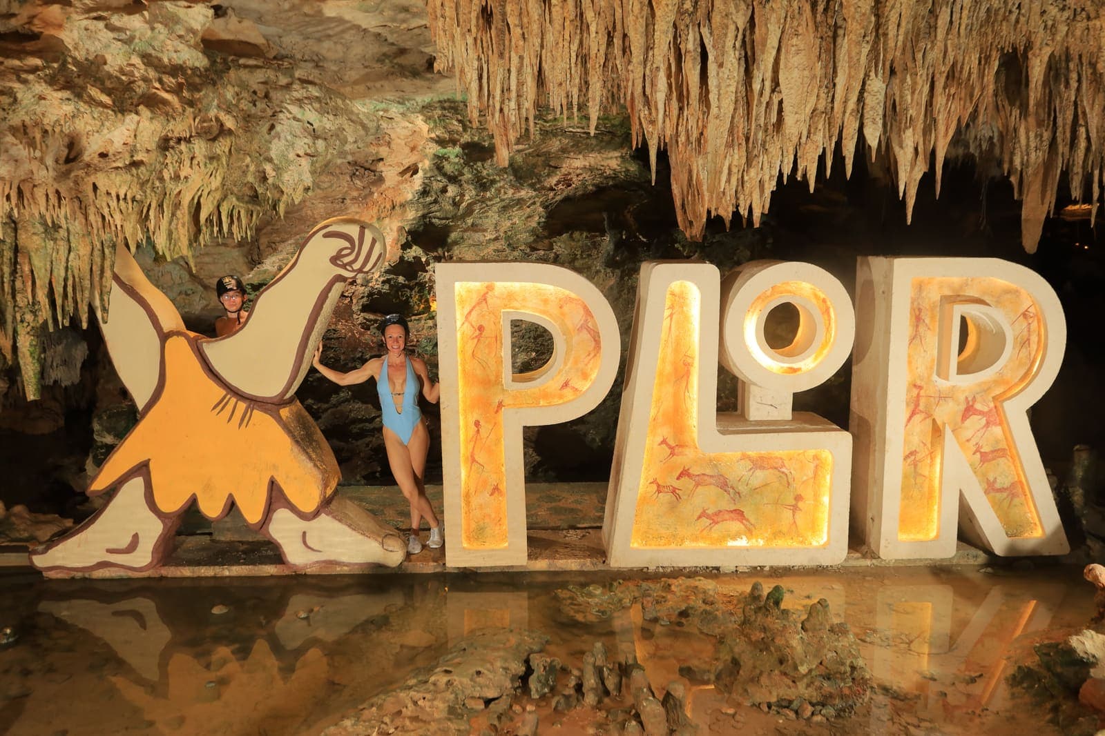 The lit XPLOR letters beneath cave stalactites, one of the two parks compared on this page